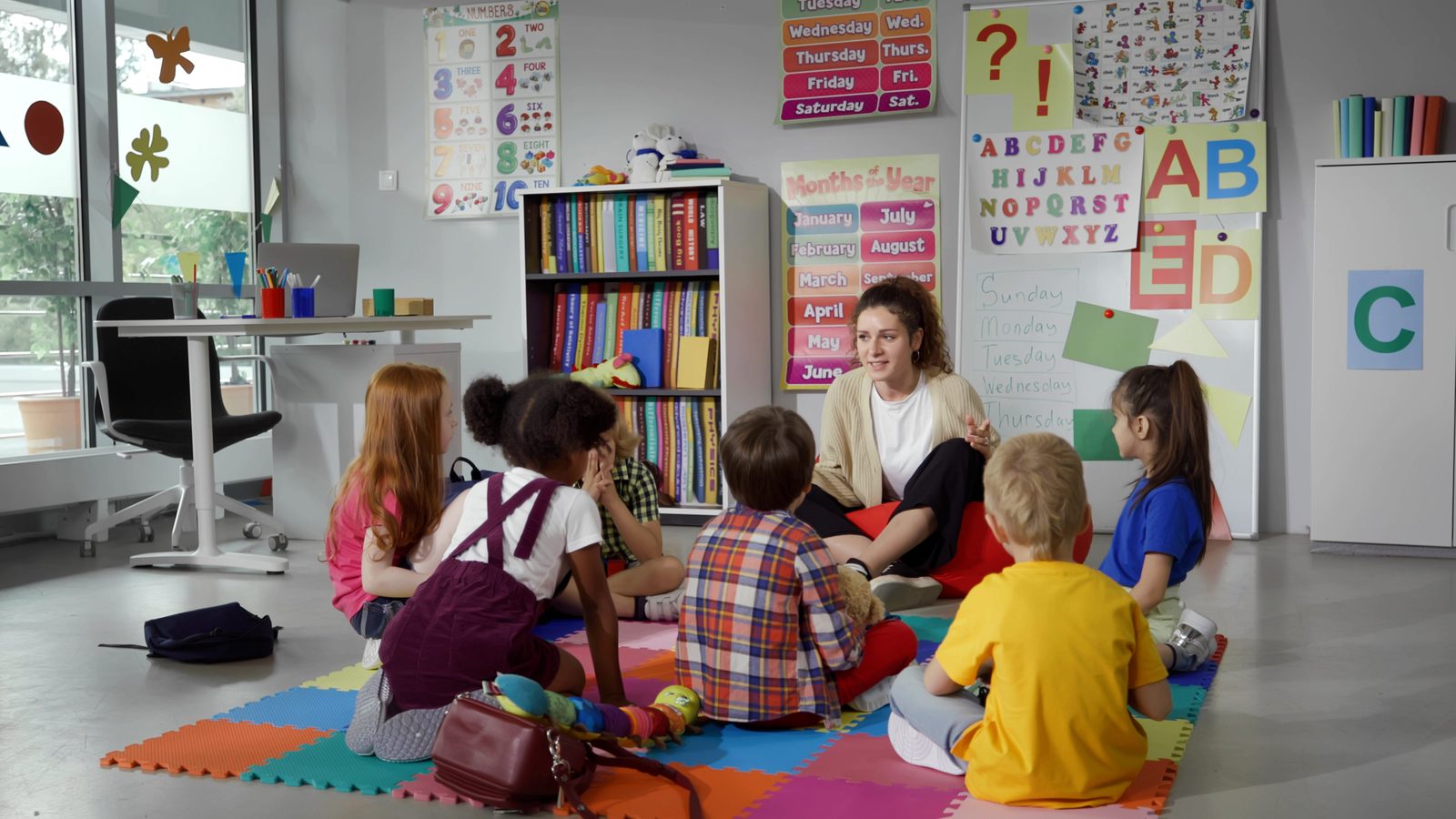 Une éducatrice fait la lecture à un groupe de jeunes enfants